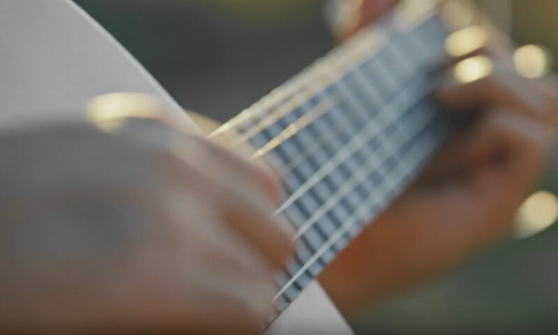 Close-up view of hands playing an acoustic guitar