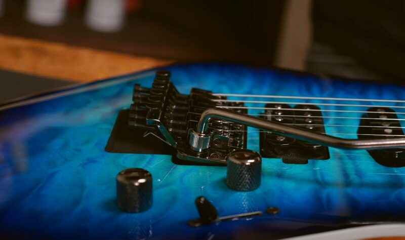 Close up photo of a guitar tuners on a bridge