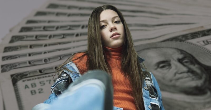 Courtney Hadwin Standing in Front of A Stack of Money