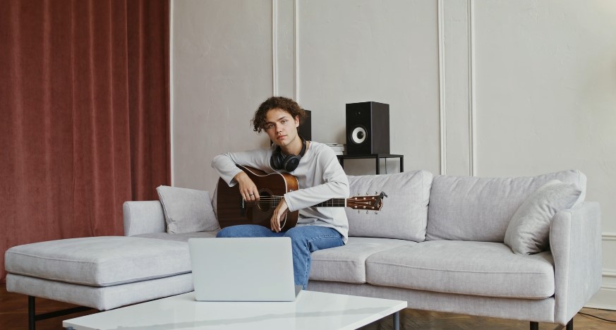 A person plays a guitar in his living room