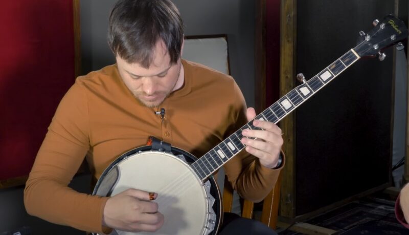 A musician meticulously plays a banjo