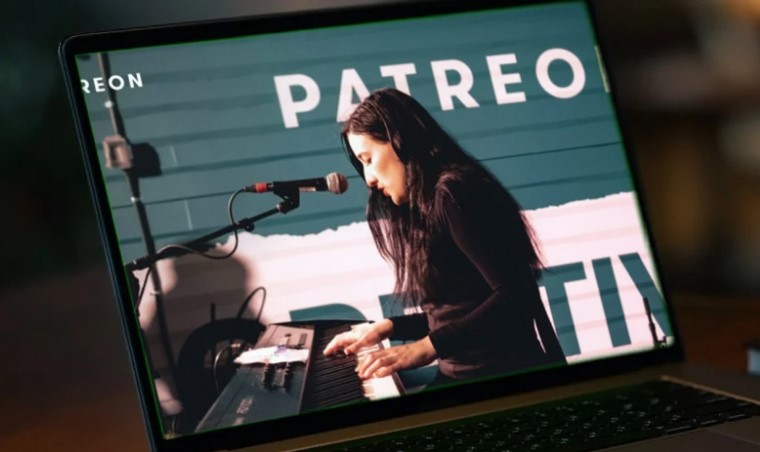 Laptop screen displays a musician playing the keyboard