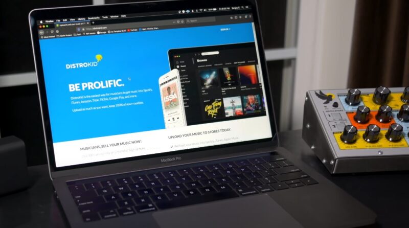 A laptop displaying a music distribution platform, Distrokid, highlighting its ease of use for musicians