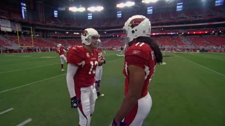 Kurt Warner and Larry Fitzgerald talking on a pitch