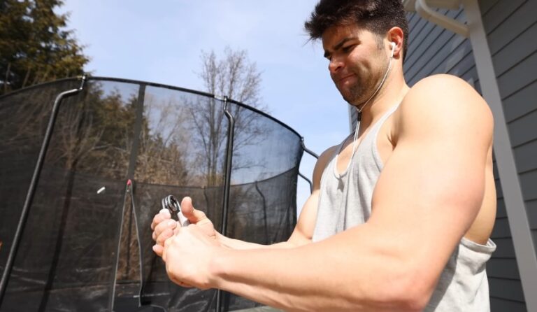 Man working with a hand-held exercise tool outdoors