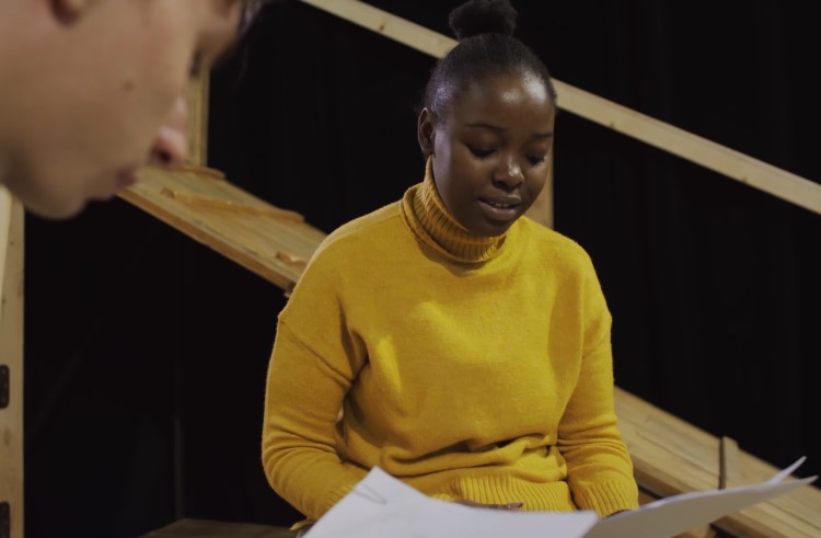 Script in hand, a student intently studies the play's dialogue