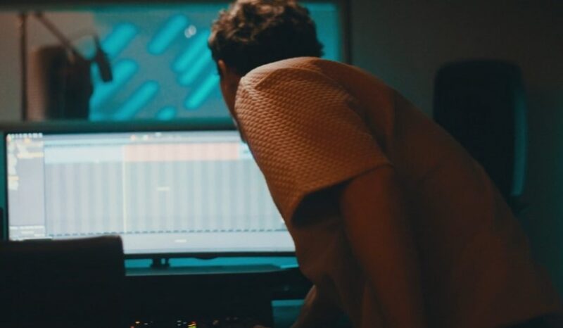 Detail of a music producer concentrating on audio editing software
