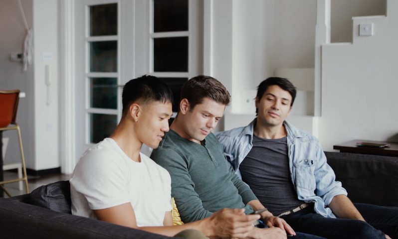 Three friends on sofa looking at phone