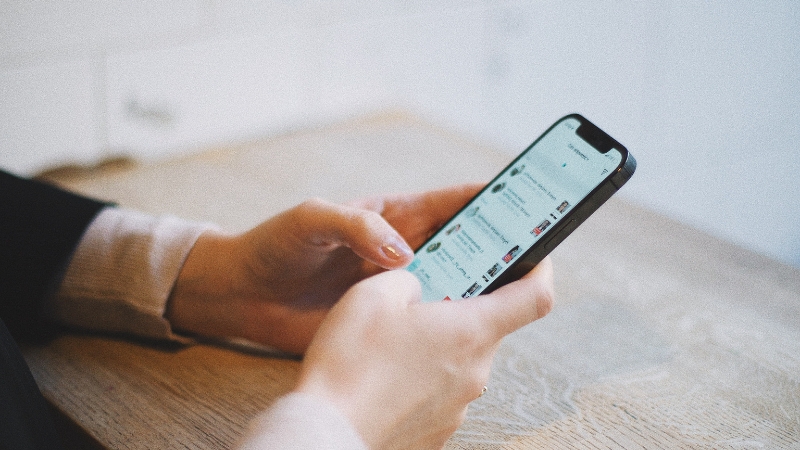 A celebrity manager checking social media updates on a smartphone during the evening
