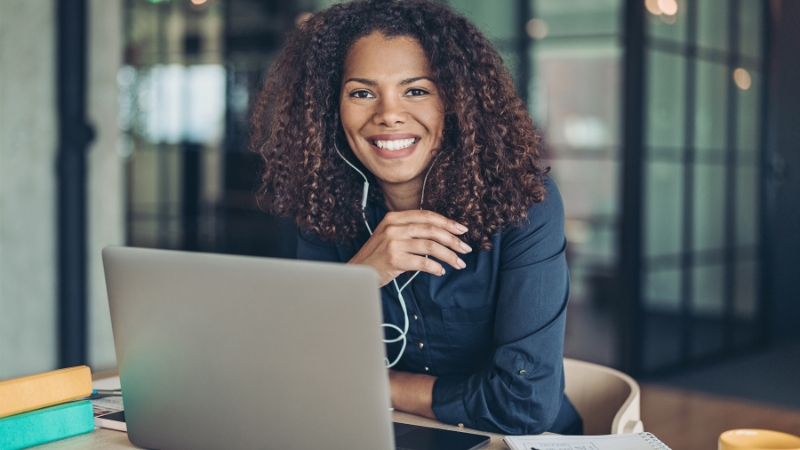 A celebrity manager working on a laptop, coordinating tasks and communications in a modern office setting
