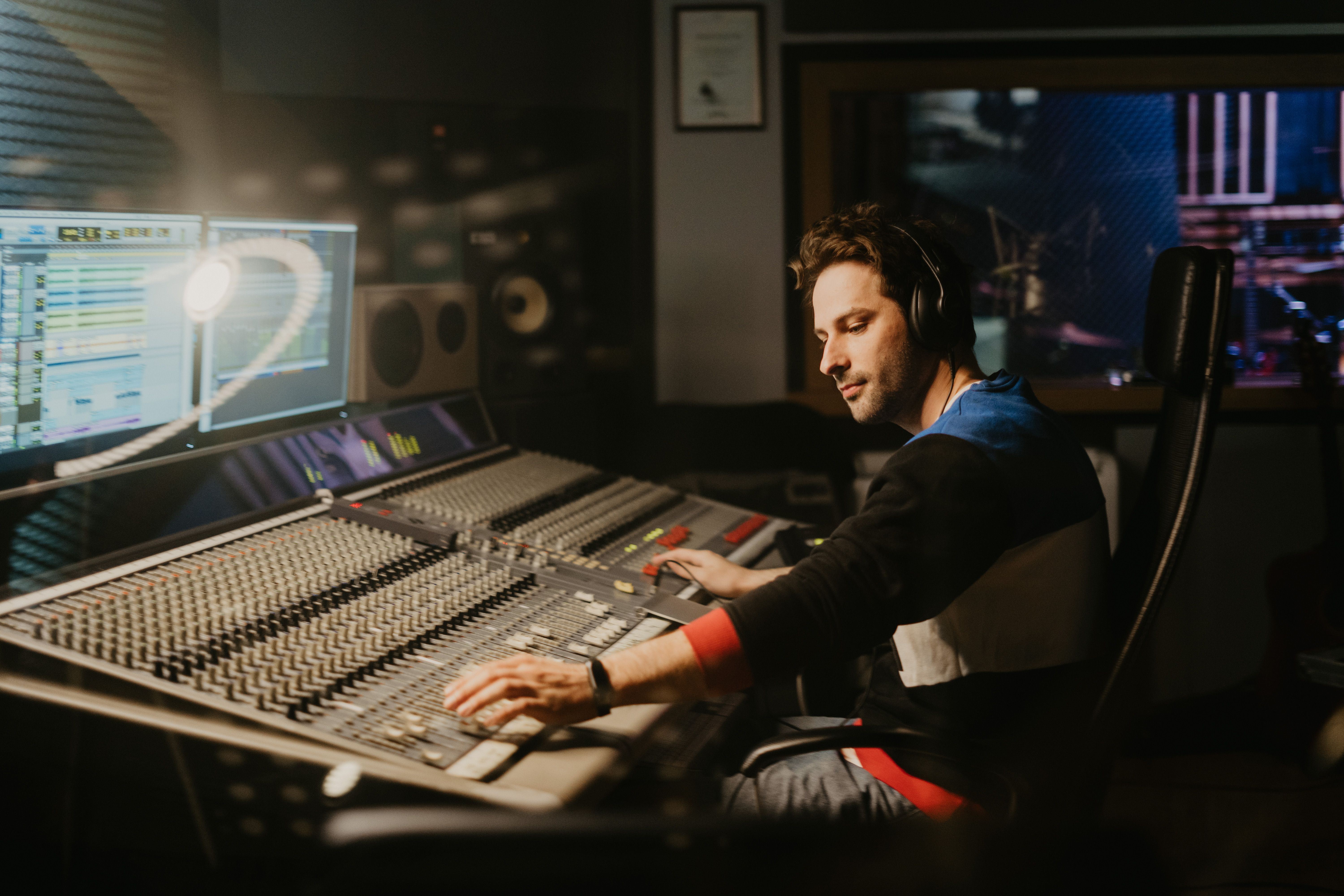 Sound engineer at a mixing console in a professional music recording studio